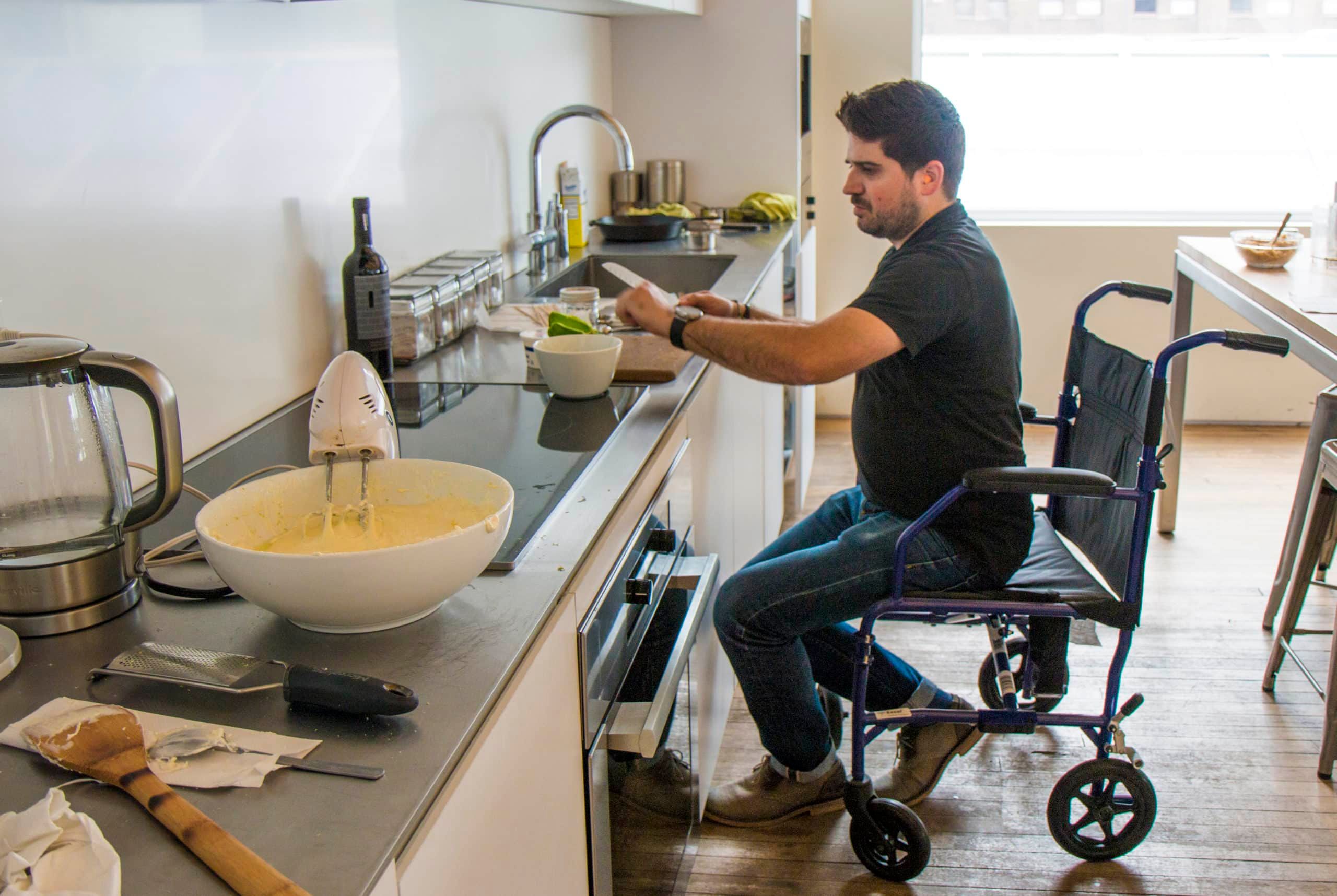 Ge Appliances Man Cooking At Counter With Mobility Walker