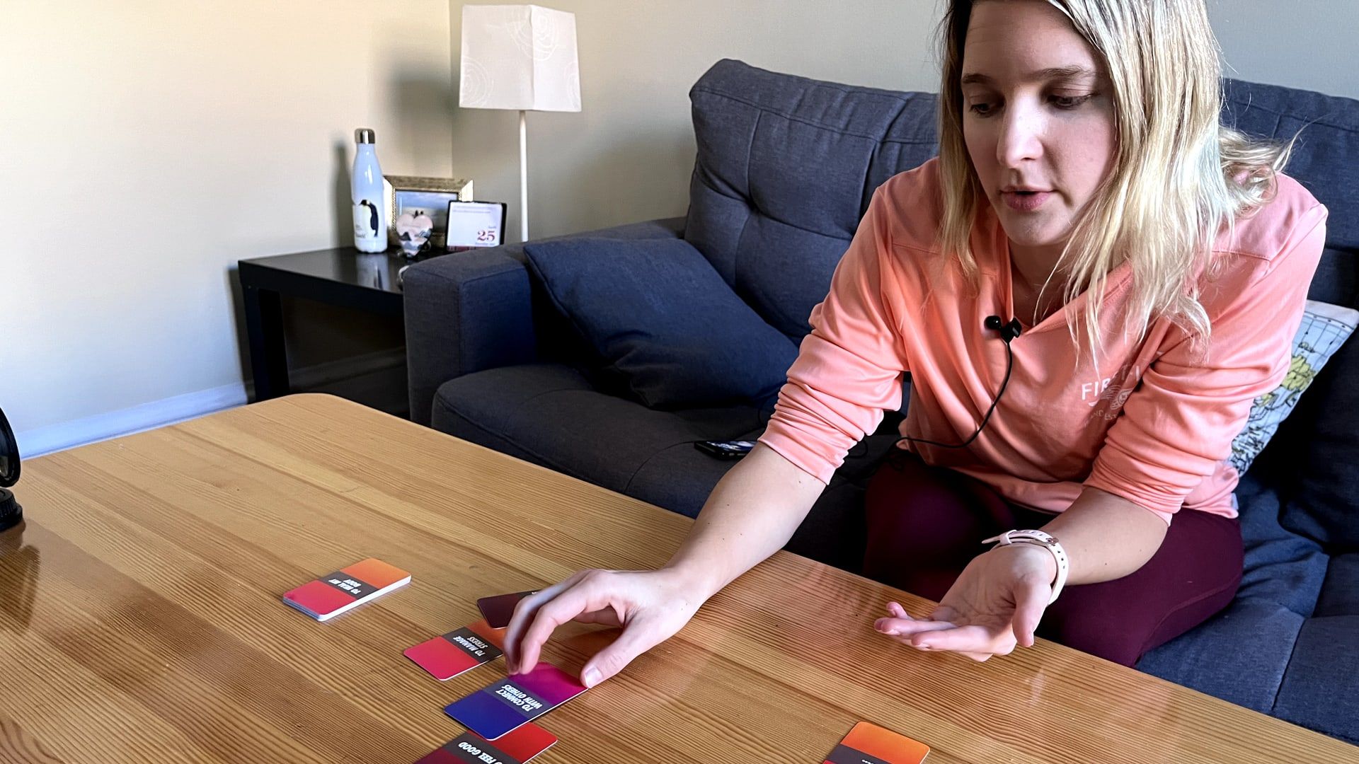 Participant on a sofa sorting colored cards on a wooden table