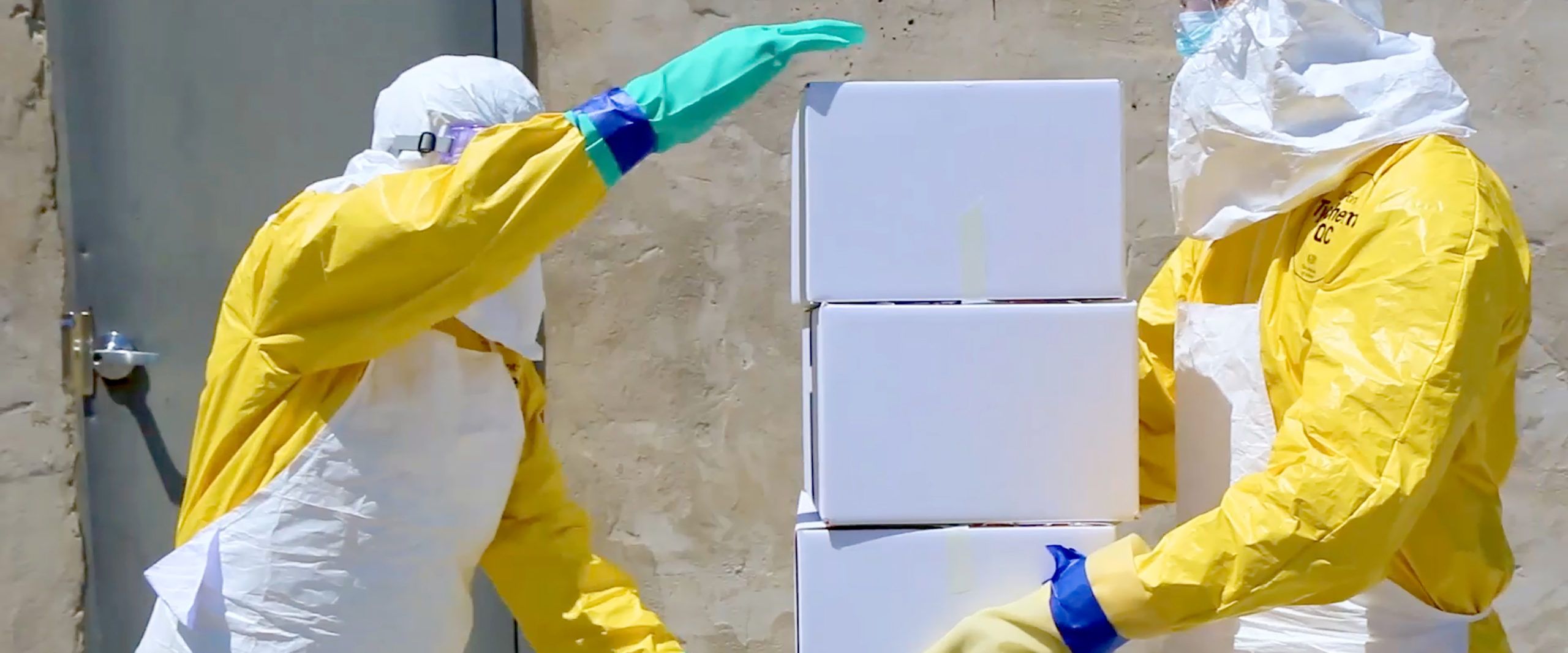 USAID Responders In Protective Suits Stacking Supply Boxes